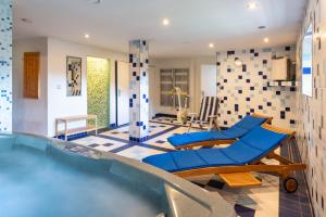 a swimming pool with blue chairs in a room at Svycarska Bouda in Špindlerův Mlýn