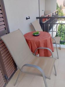 two chairs and a table with a red table cloth on a balcony at Papas Studios in Skala Marion