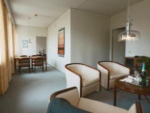 - un salon avec des chaises et une table ainsi qu'une salle à manger dans l'établissement Myllykosken Kerho Oy, à Kouvola