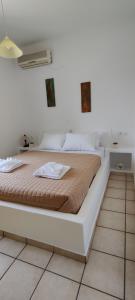 a white bed in a white room with at The Fig Tree - Deluxe Studio in Ios Chora
