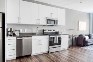 a kitchen with white cabinets and a stove top oven at Brighton 1BR w WD Gym nr T Shops Dining BOS-435 in Boston