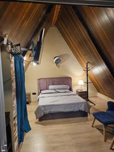 a bedroom with a large bed in a attic at Orkid Chalet in Cameron Highlands