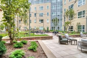 a patio with tables and chairs in front of a building at Brighton 1BR w WD Gym nr T Shops Dining BOS-435 in Boston