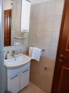 uma casa de banho com um lavatório branco e um espelho. em Mitan apartman em Tučepi