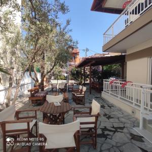 an outdoor patio with wooden tables and chairs at Nafsika in Ammouliani