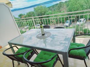 a glass table on a balcony with a view of the ocean at Apartment Lucija in Dramalj