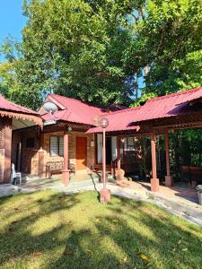 a house with a red roof and a yard at D'Impiana Riverview Chalet # Lenggong in Kampong Ulu Jepai