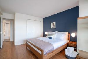 a bedroom with a large bed with blue walls at Beacon Hill 2BR wGreat Views Gym Doorman BOS-54 in Boston