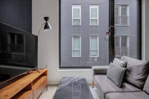 a living room with a flat screen tv and a couch at South Boston studio w wd nr red line BOS-886 in Boston