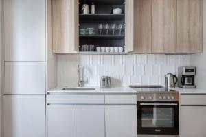 a kitchen with white appliances and wooden cabinets at South Boston studio w wd nr red line BOS-886 in Boston