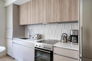 a kitchen with white cabinets and a stove top oven at South Boston studio w wd nr red line BOS-887 in Boston