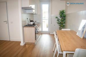 une cuisine avec une table en bois et une table et une cuisine avec un plan de travail dans l'établissement Ostia Holiday Tristano e Isotta, à Lido di Ostia