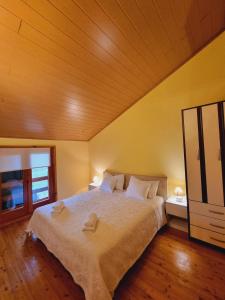 a bedroom with a large bed with a wooden ceiling at Kuća za odmor Neli in Sukošan