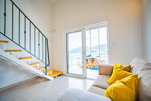 un soggiorno con divano e scala di Apartmani Bonaca a Tivat