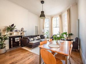 uma sala de estar com uma mesa e um sofá em Gorgeous Luxury 2 bed Maida Vale em Londres