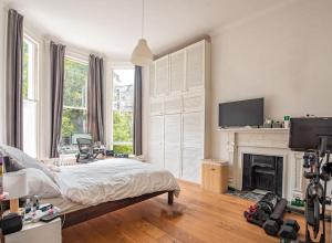 um quarto branco com uma cama e uma lareira em Gorgeous Luxury 2 bed Maida Vale em Londres