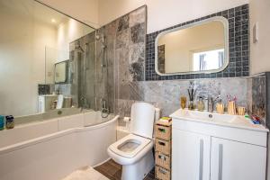 uma casa de banho com um WC, um lavatório e um espelho. em Gorgeous Luxury 2 bed Maida Vale em Londres