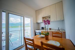 uma cozinha com uma mesa de madeira e vista para o oceano em Apartmani Bonaca em Tivat