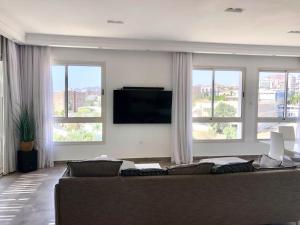 uma sala de estar com um sofá e uma televisão de ecrã plano em Private Pool Luxury Penthouse em Eilat
