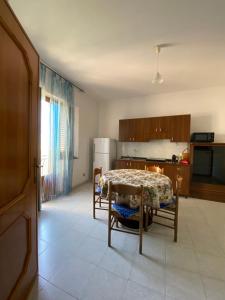a kitchen with a table and chairs and a kitchen with a refrigerator at Miramare Oliveri in Oliveri