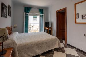 1 dormitorio con cama y ventana en Hotel Oasis, en Conil de la Frontera