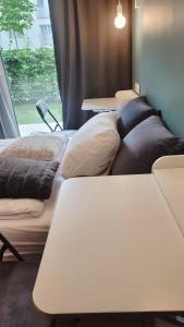 a row of beds in a room with tables at Green Terrace Family Apartment - 2 Terraces, Free Parking, NETFLIX Cinema in Wrocław +25 photos
