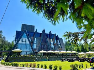 a building with tables and chairs in front of it at Pino Nature Hotel, BW Premier Collection in Sarajevo