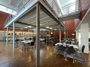 a dining area with tables and chairs in a building at Jugendherberge Wolfsburg in Wolfsburg