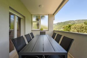 mesa de comedor con sillas y ventana en Peninsula Apartments, en Žuljana