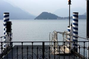 a pier with two chairs sitting on the water at Menaggio Centro in Menaggio