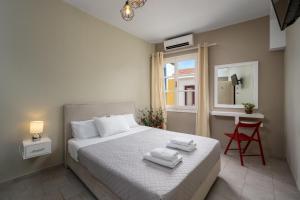 1 dormitorio con 1 cama con 2 toallas en Maravelia's Rooms en Symi