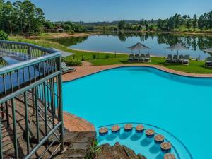 白河的住宿－Blue Zone Leisure at Pine Lake Inn Resort，一座大型游泳池,后面是湖泊