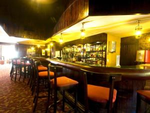 un bar con una fila de taburetes en un restaurante en Blue Zone Leisure at Pine Lake Inn Resort, en White River