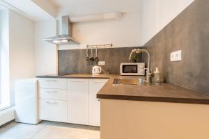 a kitchen with white cabinets and a sink at Brand new two room apartment #34 with free secure parking in the center in Prague