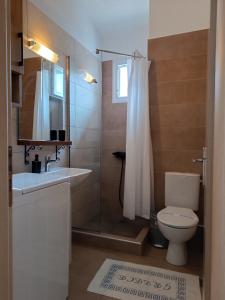 uma casa de banho com um chuveiro, um WC e um lavatório. em Niki Apartments Beach Loft em Platamon