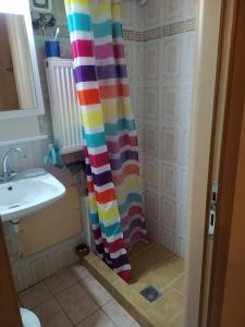 cortina de ducha en el baño con lavamanos en Blue House, en Afitos