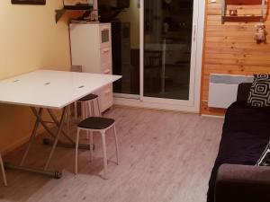 eine Küche mit einem Schreibtisch, einem Tisch und einem Sofa in der Unterkunft Appartement Les Adrets-Prapoutel, 2 pièces, 5 personnes - FR-1-557-57 in Les Adrets
