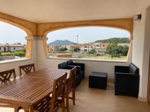 ein Esszimmer mit einem Tisch und Stühlen sowie einem großen Fenster in der Unterkunft villetta con terrazza in Posada