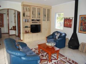 a living room with two blue chairs and a table at Ascot Gardens Self Catering in Cape Town