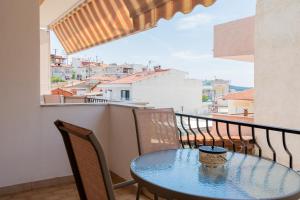 a table and chairs on a balcony with a view at Angelika Rooms in Neos Marmaras