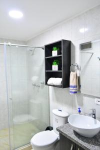y baño con aseo, lavabo y ducha. en Apartamentos cómodos en Milan zona G, en Manizales