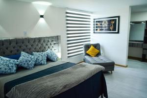 マニサレスにあるApartamentos cómodos en Milan zona Gのベッドルーム(大型ベッド1台、椅子付)