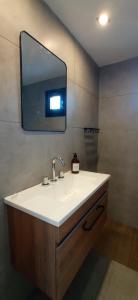 baño con lavabo y espejo en la pared en Casa terraza Quequén en Quequén