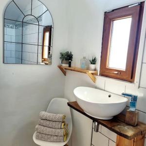 bagno con lavandino bianco e specchio di Tamarisk Cabin a Bude