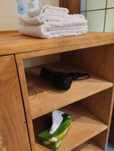 a wooden shelf with a bottle and towels on it at La casa di Ottavio in Giaveno