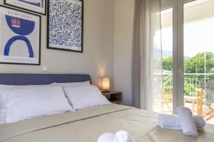 a bedroom with a bed and a large window at The Olympus Estate in Litochoro