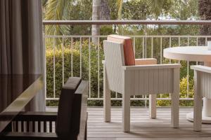 a white chair and a table on a balcony at Cap d'Antibes Beach Hotel in Juan-les-Pins