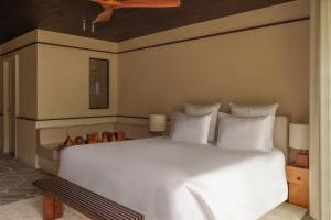 a bedroom with a large white bed with white pillows at Cap d'Antibes Beach Hotel in Juan-les-Pins