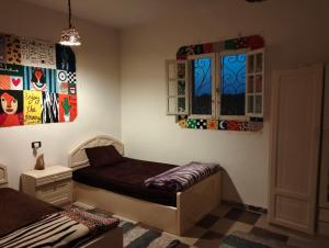 a bedroom with a bed and two windows at Friendo's House & Hot Spring in Siwa +70 photos