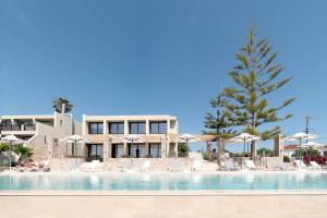 a resort with a swimming pool with chairs and umbrellas at Achilles Hill Hotel in Methoni